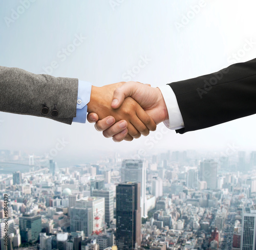 Photo: businessman and businesswoman shaking hands businessman and businesswoman shaking hands