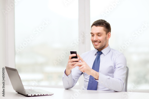 Photo: businessman with laptop and smartphone at office businessman with laptop and smartphone at office