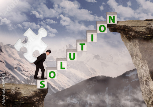 Photo: Business manager bring puzzle solution on mountain Business manager bring puzzle solution on mountain