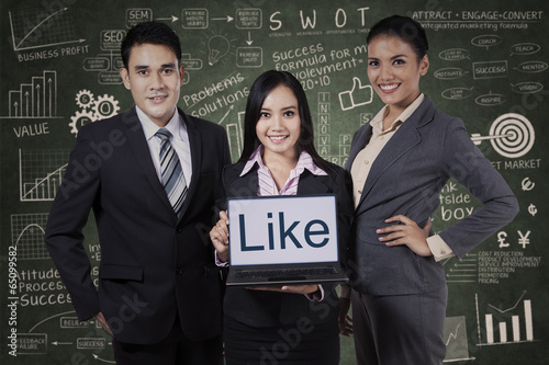 Photo: Business team showing like on laptop Business team showing like on laptop