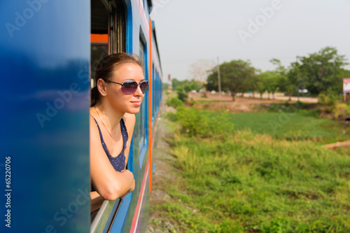 Photo: Young woman passenger looking trough window Young woman passenger looking trough window