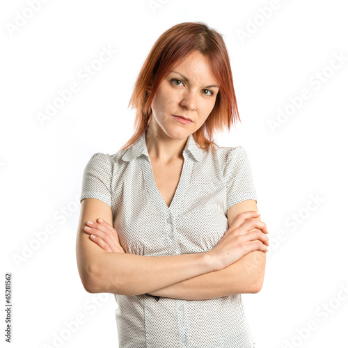 Photo: Young woman with hers arms crossed over white background Young woman with hers arms crossed over white background