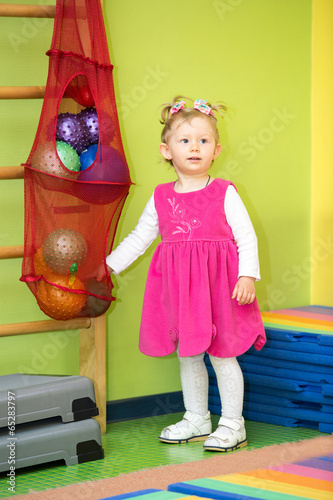 Photo: Little child girl playing with ball in kindergarten Little child girl playing with ball in kindergarten