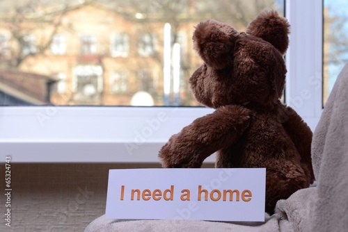 Photo: Toy-bear looking out window close-up Toy-bear looking out window close-up