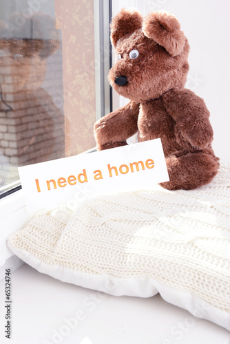 Photo: Toy-bear looking out window close-up Toy-bear looking out window close-up