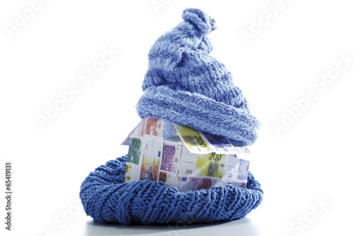 Photo: Haus aus Euro-Scheinen in Schal und Mütze eingewickelt Haus aus Euro-Scheinen in Schal und Mütze eingewickelt