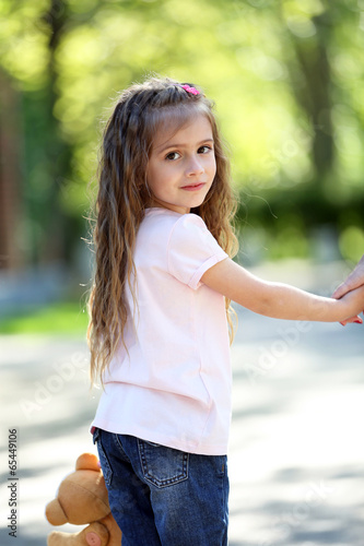 Photo: Happy little girl in the green park Happy little girl in the green park