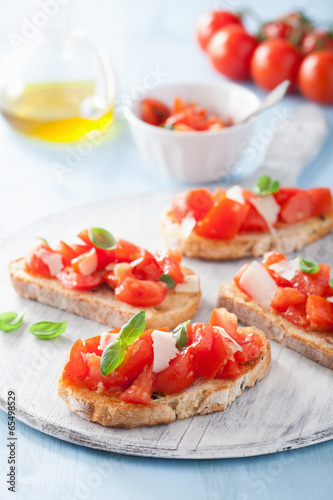 Photo: Italian bruschetta with tomatoes, parmesan, garlic and olive oil Italian bruschetta with tomatoes, parmesan, garlic and olive oil