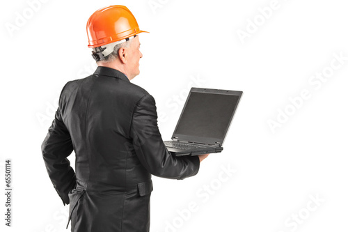 Photo: Mature architect holding a laptop Mature architect holding a laptop