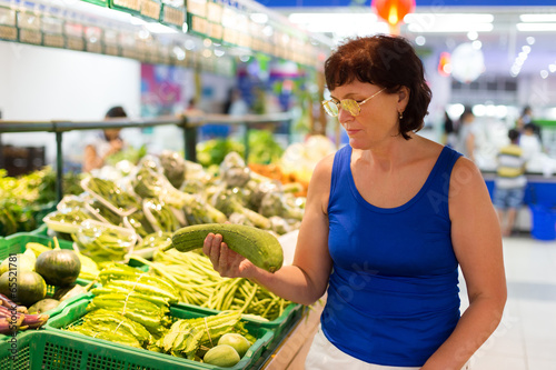 Photo: woman buys zucchini woman buys zucchini