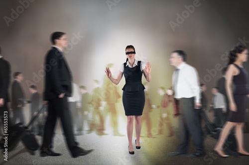 Photo: Composite image of redhead businesswoman in a blindfold Composite image of redhead businesswoman in a blindfold