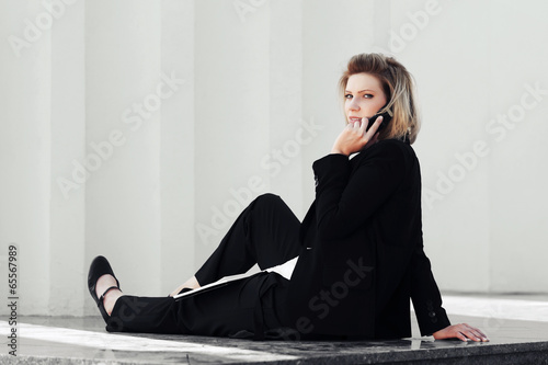 Photo: Young business woman calling on the cell phone Young business woman calling on the cell phone
