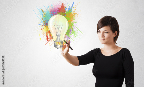 Photo: Young lady drawing a colorful light bulb with colorful splashes Young lady drawing a colorful light bulb with colorful splashes