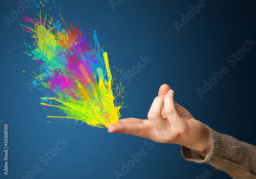 Photo: Colorful splashes are coming out of gun shaped hands Colorful splashes are coming out of gun shaped hands
