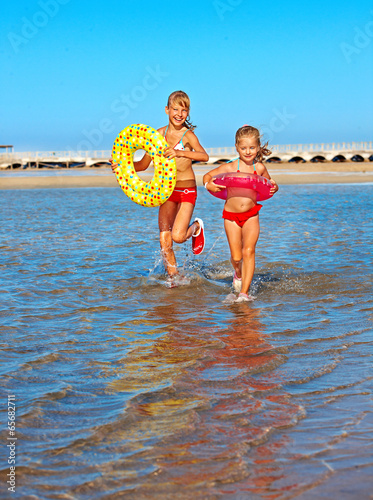 Photo: Children holding hands running on beach. Children holding hands running on beach.