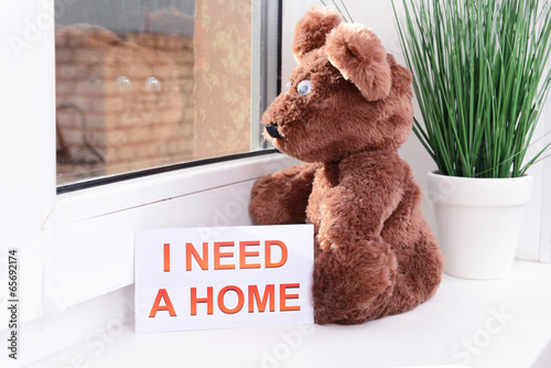 Photo: Toy-bear looking out window close-up Toy-bear looking out window close-up