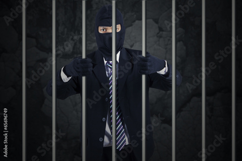 Photo: Businessman wearing a mask in jail Businessman wearing a mask in jail
