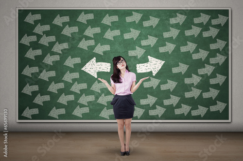 Photo: Businesswoman with arrows on blackboard Businesswoman with arrows on blackboard