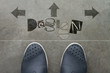Hand drawn DESIGN design word on front of business man feet as c Hand drawn DESIGN design word on front of business man feet as c