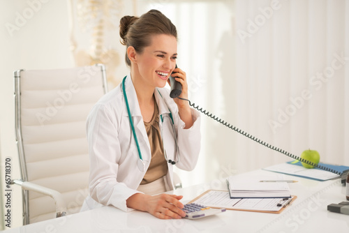 Photo: Happy medical doctor woman talking phone Happy medical doctor woman talking phone
