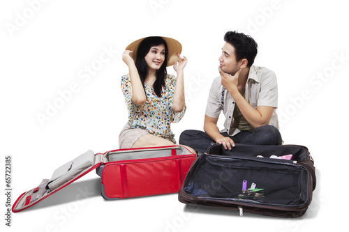 Photo: Two tourists opening luggage Two tourists opening luggage