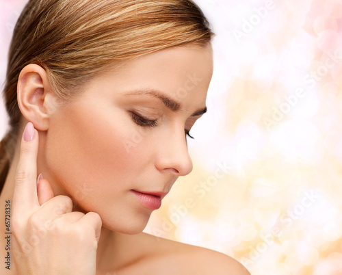 Photo: calm woman touching her ear calm woman touching her ear