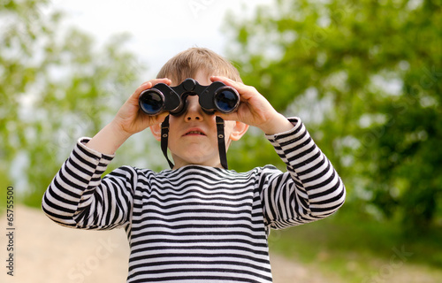Photo: Little boy scanning the woods with binoculars Little boy scanning the woods with binoculars