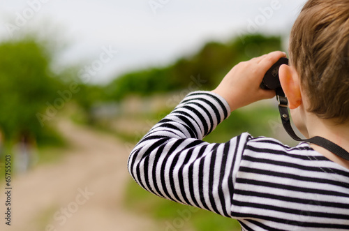 Photo: Little boy scanning the woods with binoculars Little boy scanning the woods with binoculars