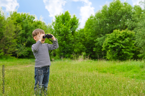 Photo: Little boy scanning the woods with binoculars Little boy scanning the woods with binoculars
