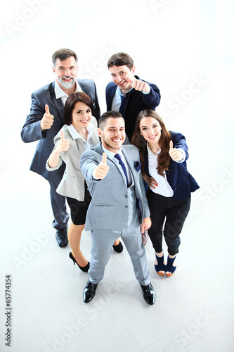 Photo: Top view of successful young business people showing thumbs up Top view of successful young business people showing thumbs up