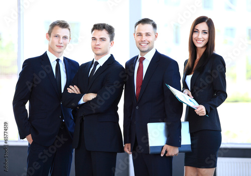 Photo: professional business team looking confidently at camera professional business team looking confidently at camera