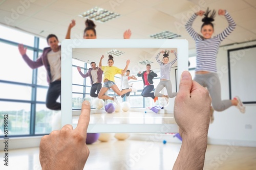 Photo: Composite image of hand holding tablet pc Composite image of hand holding tablet pc