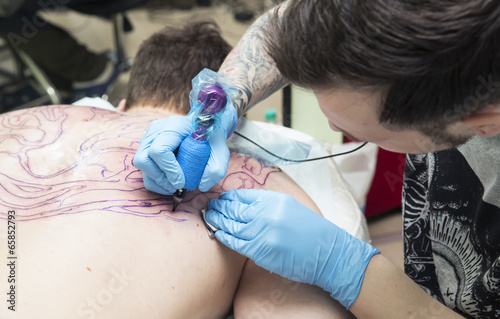 Photo: Tattooer does a tattoo Tattooer does a tattoo