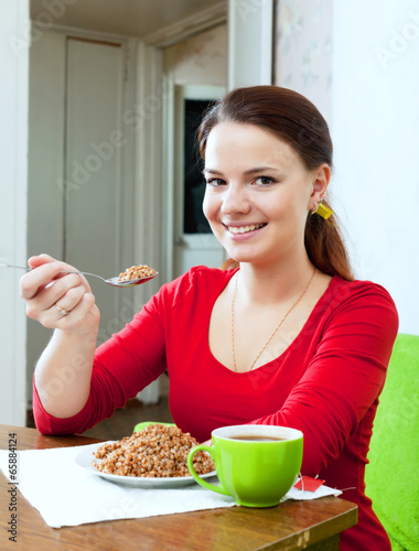 Photo: Happy girl eats buckwheat Happy girl eats buckwheat