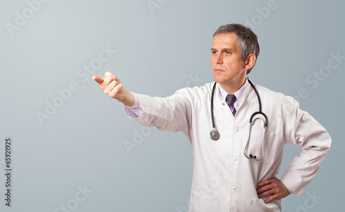 Photo: Middle aged doctor gesturing with copy space Middle aged doctor gesturing with copy space