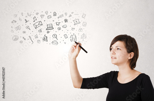 Photo: Young woman drawing and sketching icons and symbols Young woman drawing and sketching icons and symbols