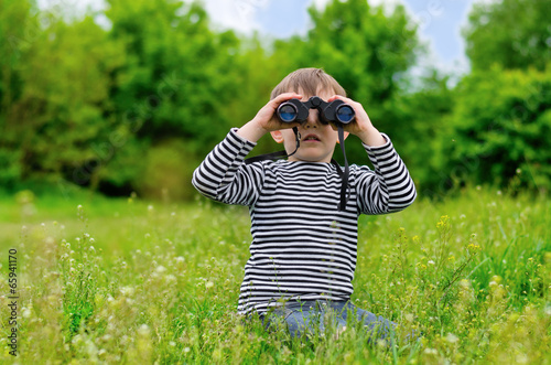 Photo: Little boy scanning the woods with binoculars Little boy scanning the woods with binoculars