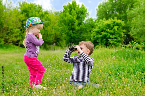 Photo: Little girl and boy playing with binoculars Little girl and boy playing with binoculars