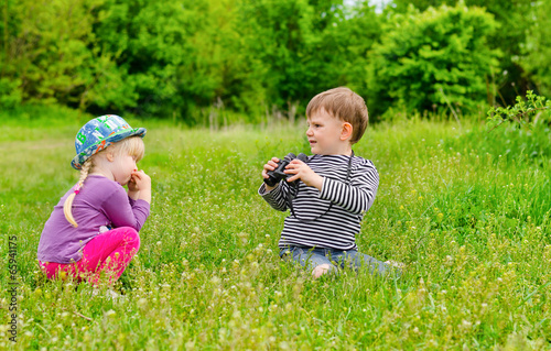 Photo: Little girl and boy playing with binoculars Little girl and boy playing with binoculars
