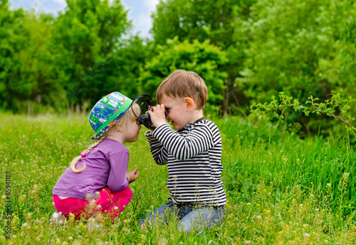 Photo: Young boy and girl playing with binoculars Young boy and girl playing with binoculars