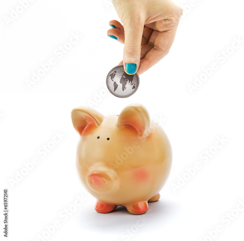 Photo: Hand depositing coin with World map in piggy bank Hand depositing coin with World map in piggy bank