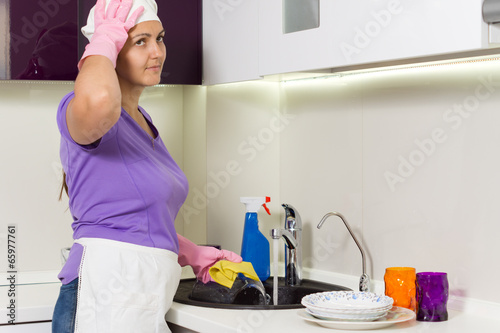 Photo: Housewife straightening her cap as she works Housewife straightening her cap as she works