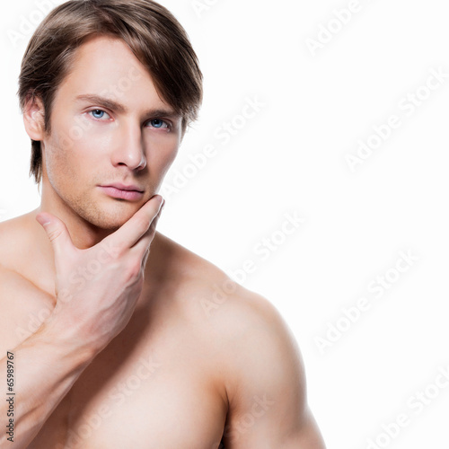 Photo: Young man with hand near the face. Young man with hand near the face.