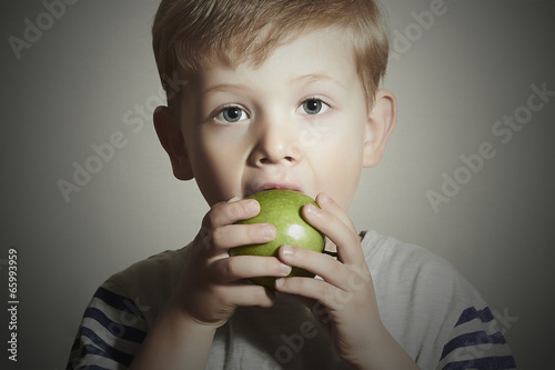 Photo: Funny Child eating apple.Little Boy.Health food. Fruits Funny Child eating apple.Little Boy.Health food. Fruits