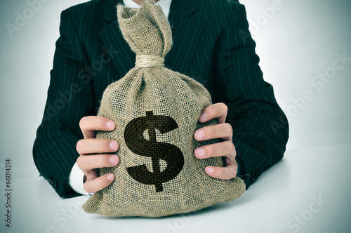 Photo: man in suit with a burlap money bag man in suit with a burlap money bag