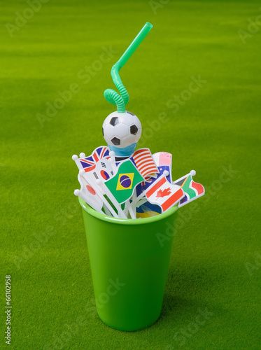 Photo: Drinking straw in green cup with many nation flag Drinking straw in green cup with many nation flag