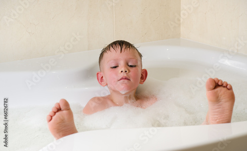 Photo: Boy having a relaxing bubble bath Boy having a relaxing bubble bath