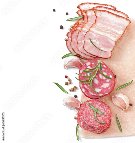 Photo: Assorted deli meats, rosemary and pepper, isolated on white Assorted deli meats, rosemary and pepper, isolated on white