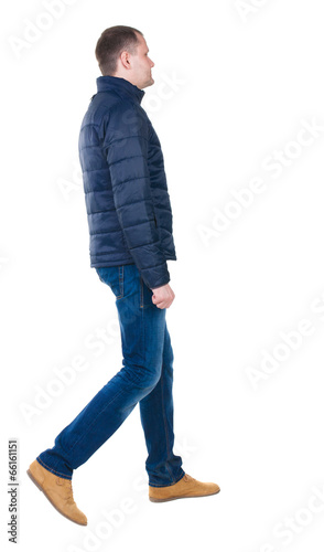 Photo: Back view of going handsome man in jeans and jacket. Back view of going handsome man in jeans and jacket.