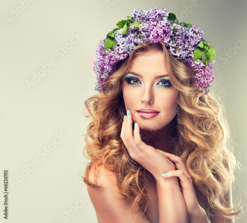 Photo: Beautiful model of flowers lilac ,with curly long hair. Beautiful model of flowers lilac ,with curly long hair.